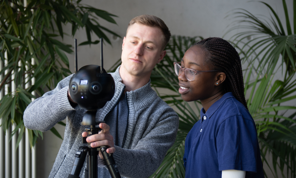 Zwei Personen justieren eine 360-Grad Kamera.